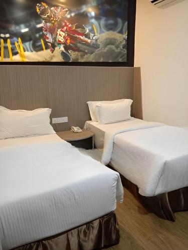 a hotel room with two beds and a painting on the wall at Hype Motorsport Hotel Nilai in Nilai