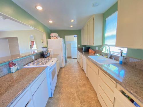 a kitchen with white counters and a white refrigerator at WHOLE Family - Edison in Sacramento