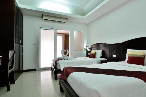 Ένα ή περισσότερα κρεβάτια σε δωμάτιο στο Samui First House Hotel