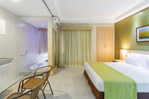 a hotel room with a bed and a bathroom at Hotel Hot Springs 528 in Caldas Novas