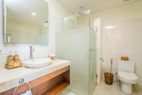 bagno bianco con lavandino e servizi igienici di Tebesaya Cottage by Pramana Villas ad Ubud