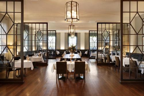Mineral Springs Hotel Hepburn في هيبورن سبرينغز: مطعم بطاولات بيضاء وكراسي ونوافذ