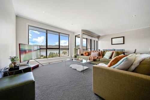 a living room with a couch and a television at Jasper 4 - 3BR Apartment l Central Location l Lake Views l WiFi l Air-Con in Jindabyne