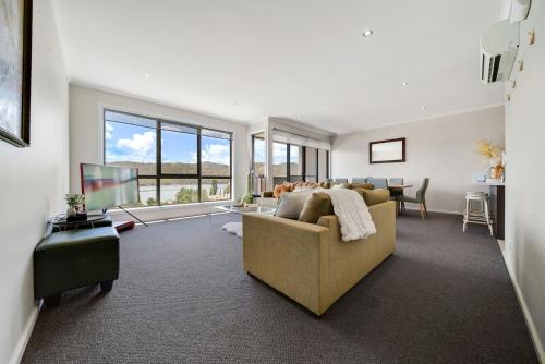 a living room with a couch and a television at Jasper 4 - 3BR Apartment l Central Location l Lake Views l WiFi l Air-Con in Jindabyne