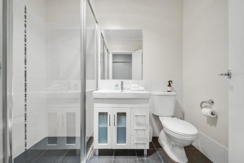 a white bathroom with a toilet and a shower at Jasper 4 in Jindabyne