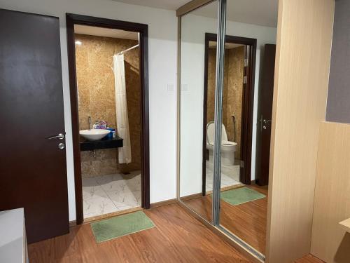 La salle de bains est pourvue d'une douche, de toilettes et d'un lavabo. dans l'établissement Luxury Apartemen Grand Lagoon Sungkono Surabaya, à Dukuhpakis