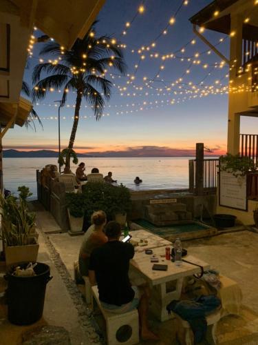 a group of people sitting at a table watching the sunset at Rin Bay View Resort in Haad Rin