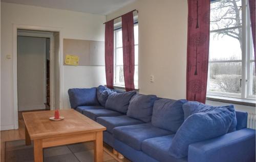 a blue couch in a living room with a table at 7 Bedroom Awesome Home In Tomelilla in Tomelilla