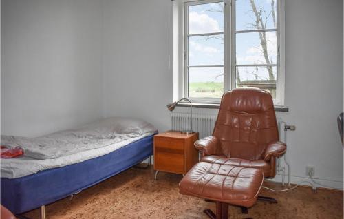 a bedroom with a bed and a chair next to a window at 7 Bedroom Awesome Home In Tomelilla in Tomelilla