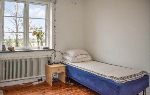 a small bedroom with a bed and a window at 7 Bedroom Awesome Home In Tomelilla in Tomelilla