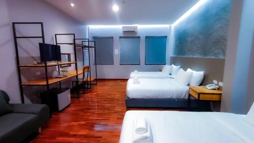 a hotel room with two beds and a couch at The Riva Vientiane Hotel in Vientiane