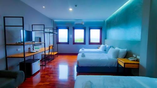 a blue room with a bed and a couch at The Riva Vientiane Hotel in Vientiane