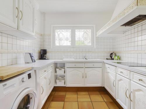 une cuisine avec des armoires blanches et une laveuse et une sécheuse dans l'établissement Maison 6 pers, proche plage, centre Biscarrosse, jardin avec barbecue, animaux acceptés - FR-1-521-149, à Biscarrosse