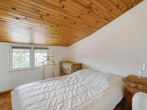 une chambre avec un lit et un plafond en bois dans l'établissement Maison 6 pers, proche plage, centre Biscarrosse, jardin avec barbecue, animaux acceptés - FR-1-521-149, à Biscarrosse