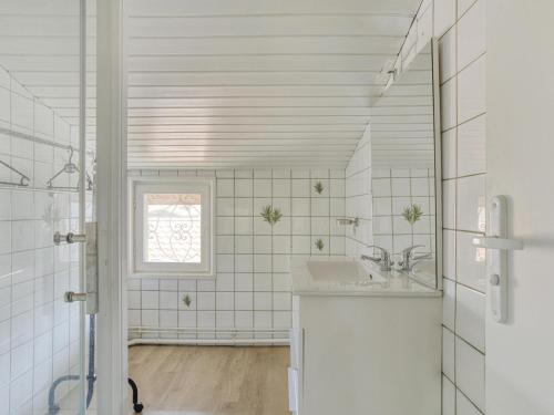 une salle de bain blanche avec un lavabo et une fenêtre dans l'établissement Maison 6 pers, proche plage, centre Biscarrosse, jardin avec barbecue, animaux acceptés - FR-1-521-149, à Biscarrosse