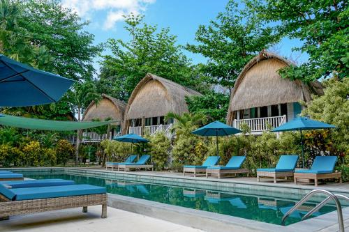a pool at a resort with chairs and umbrellas at Hai Tide Beach Resort in Nusa Lembongan