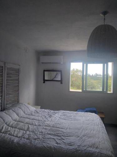 Un dormitorio con una cama grande y una ventana en Sierras de Paz en Villa Giardino