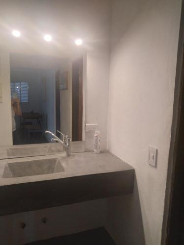 W łazience znajduje się umywalka i lustro. w obiekcie Sierras de Paz w mieście Villa Giardino