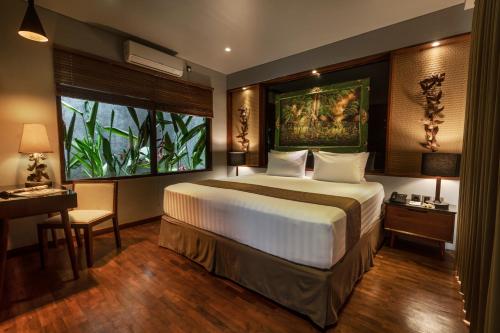 a bedroom with a large bed and a window at Agranusa Signature Villa Nusa Dua in Nusa Dua