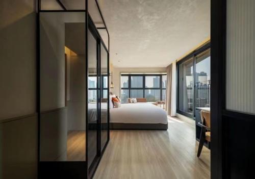a bedroom with a bed and a large window at Mia Hotel - Shanghai Shaanxi South Road in Shanghai