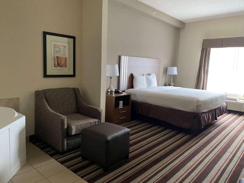 a hotel room with a bed and a chair at Best Western Windsor Inn and Suites in Danville