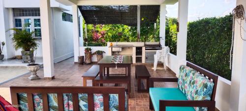 eine abgeschirmte Veranda mit einem Tisch und Stühlen in der Unterkunft Casa Quinta Flower in Melgar