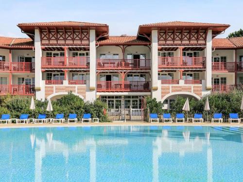 un hôtel avec une piscine devant un immeuble dans l'établissement Appartement à Biscarrosse avec Piscine, Boulodrome et Terrasse – 7 Personnes, Ménage Inclus - FR-1-319-497, à Biscarrosse