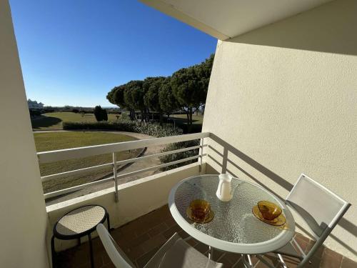 une table et des chaises sur un balcon avec vue dans l'établissement Studio Cabine 4 Couchages avec Terrasse et Parking Privé, Accès Direct Plage - Port Camargue - FR-1-250-245, au Grau-du-Roi