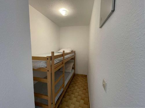 une petite pièce avec deux lits superposés dans l'établissement Studio Cabine 4 Couchages avec Terrasse et Parking Privé, Accès Direct Plage - Port Camargue - FR-1-250-245, au Grau-du-Roi