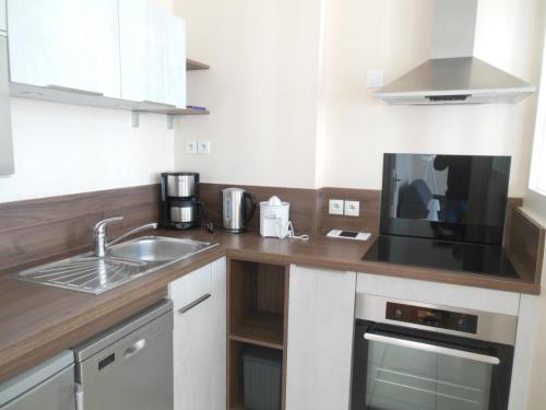 une cuisine avec un évier et un micro-ondes dans l'établissement Appartement face à la plage avec WiFi, terrasse et équipements complets - FR-1-376-112, à Boulogne-sur-Mer