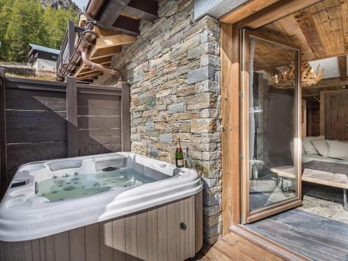 ヴァル・ディゼールにあるAppartement Val-d'Isère, 4 pièces, 6 personnes - FR-1-567-99の家の横に座ってジャグジータブ