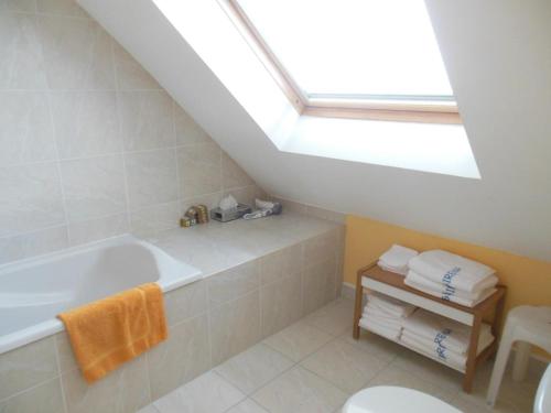 a bathroom with a bath tub and a skylight at Duplex face plage avec terrasse, 3 ch, 2 sdb, WiFi, ménage inclus - FR-1-376-113 in Boulogne-sur-Mer