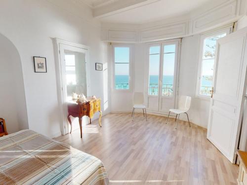 une chambre avec un lit, une table et des chaises dans l'établissement Grand 2P face mer en centre-ville dans un palace avec parc à Menton - FR-1-196-318, à Menton