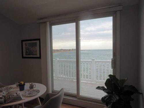 a room with a large window with a view of the ocean at Casa al Mare Beachfront Retreat King Bed Near Yale in East Haven
