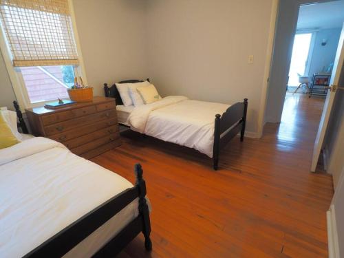 a bedroom with two beds and a wooden floor at Casa al Mare Beachfront Retreat King Bed Near Yale in East Haven