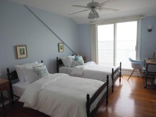 a bedroom with two beds and a ceiling fan at Casa al Mare Beachfront Retreat King Bed Near Yale in East Haven