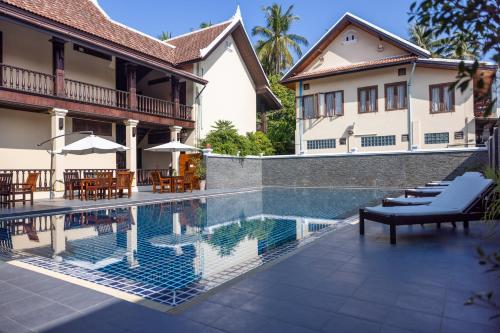 a house with a swimming pool in front of a house at Sada Hotel in Luang Prabang