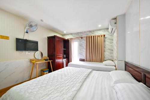 um quarto de hotel com duas camas e uma televisão em Gia Hoa Airport Hotel em Ho Chi Minh