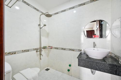 胡志明市的住宿－Gia Hoa Airport Hotel，一间带水槽、卫生间和镜子的浴室