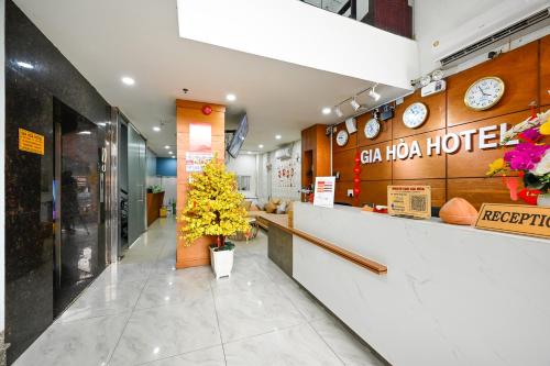a restaurant with a lobby with a counter with yellow flowers at Gia Hoa Airport Hotel in Ho Chi Minh City