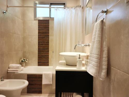y baño con lavabo, bañera y aseo. en G&G Apartments - Recoleta Boutique Experience en Buenos Aires