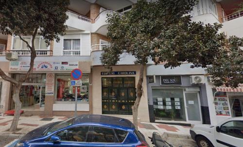 una macchina blu parcheggiata di fronte a un edificio di Joan Miró Luxury Torremolinos a Torremolinos