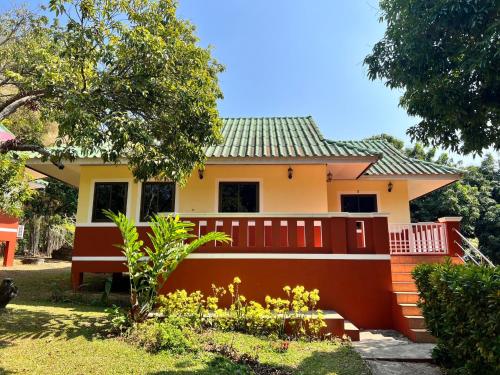 une maison avec une clôture rouge devant elle dans l'établissement ViangPhing Resort, à Mae Chan