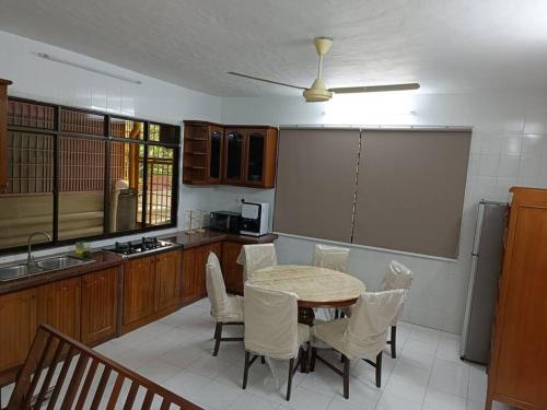 a kitchen with a table and chairs in a kitchen at Cosy and family friendly house in Sungai Petani