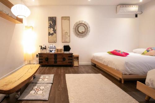 a bedroom with two beds and a table and a mirror at Bias K-girl Guesthouse - Women only in Seoul