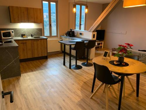 une cuisine avec une table et des chaises dans une pièce dans l'établissement Ferme La Tourelle, nature & vue exceptionnelle, à Sainte-Marie-aux-Mines