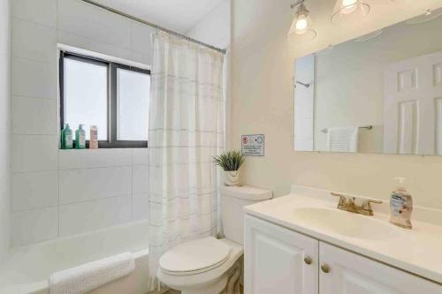 a bathroom with a toilet and a sink and a mirror at Modern & Beachy-Rlx space for 6ppl in Fort Lauderdale