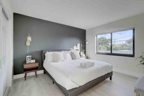 a bedroom with a large white bed and a window at Modern & Beachy-Rlx space for 6ppl in Fort Lauderdale