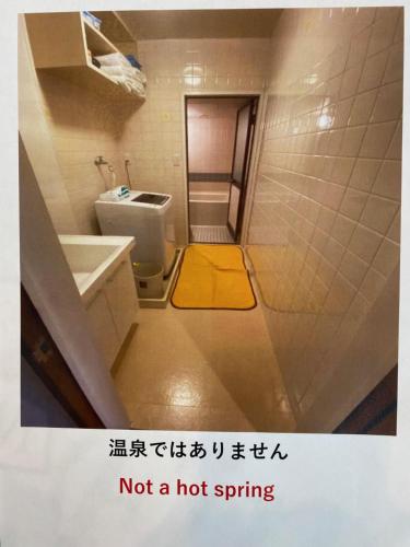 uma casa de banho com um WC e um tapete amarelo em Marina Bay Atami em Atami