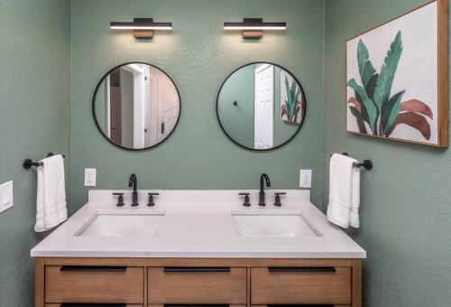 a bathroom with a white sink and two mirrors at Tropical Playhouse. Heated Pool . Spa . Golf . FUN in Lake Havasu City